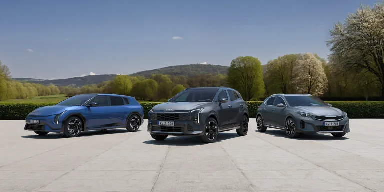 Drei Kia Fahrzeuge auf frühlingshaftem Hintergrund